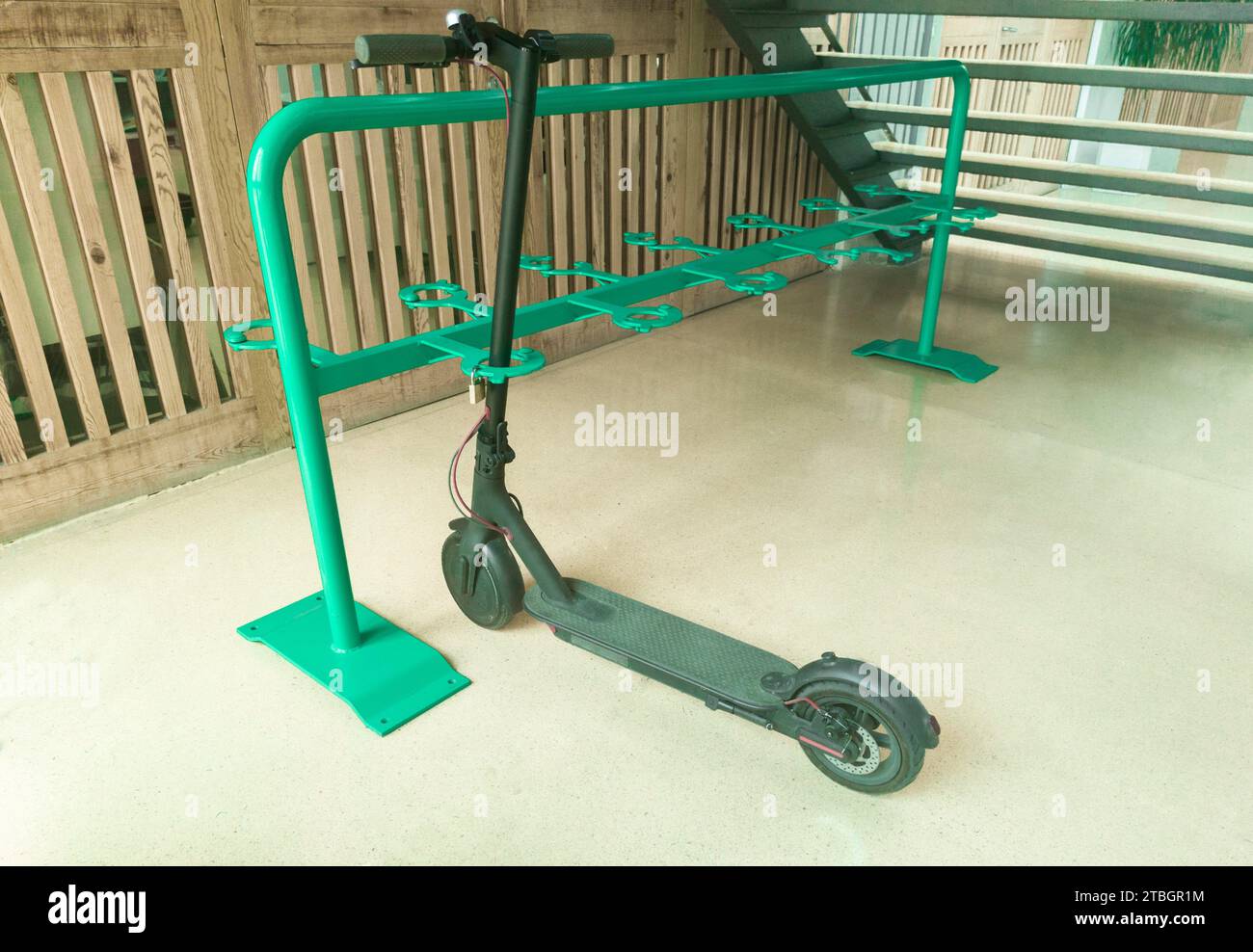Electric kick scooters parking indoor. One locked Escooter Stock Photo