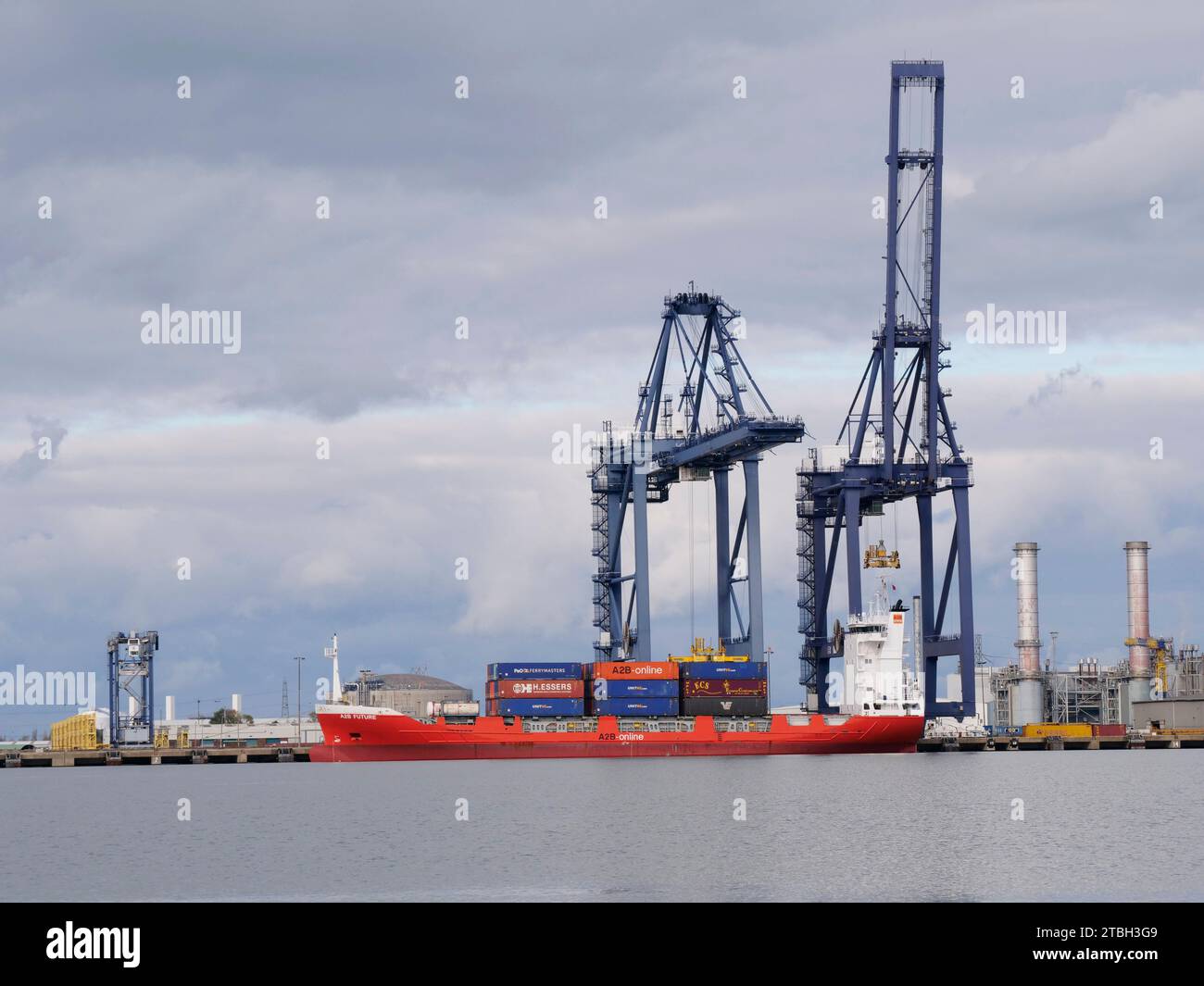 A Small container ship moored at Thames Port on the River Medway in Kent UK load ing and unloading shipping containers Stock Photo