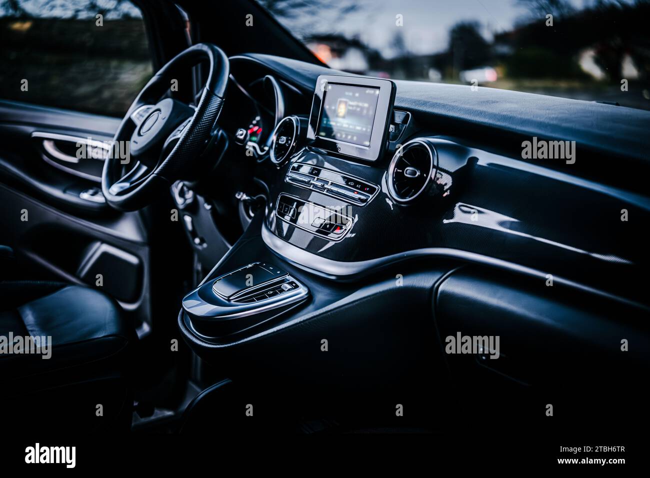 Closeup of the steering wheel, LCD radio, and gear shift lever in a