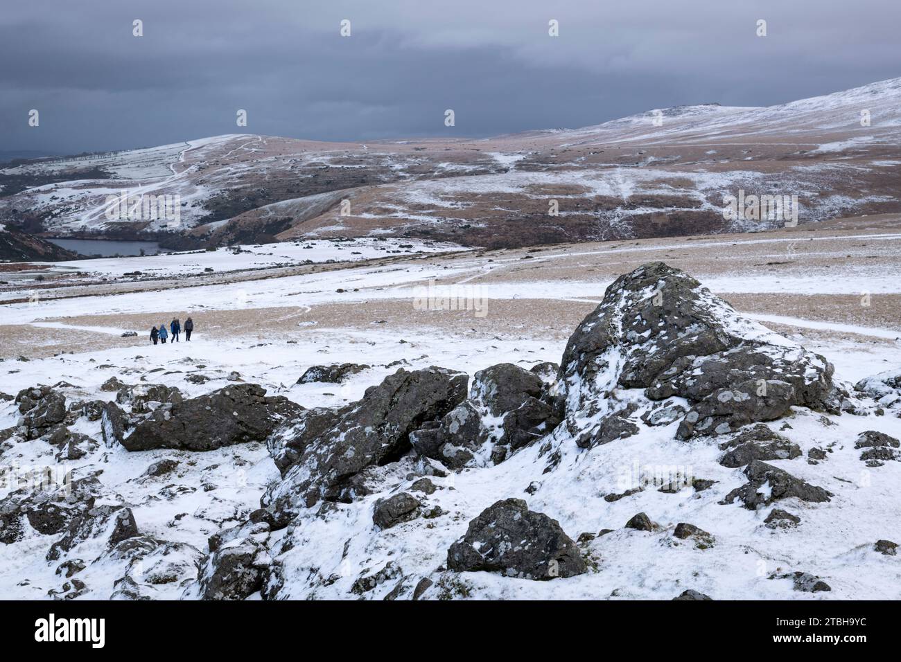 Hikers on Sourton Tor on a snowy winter day, Dartmoor National Park, Devon, England. Winter (January) 2023. Stock Photo