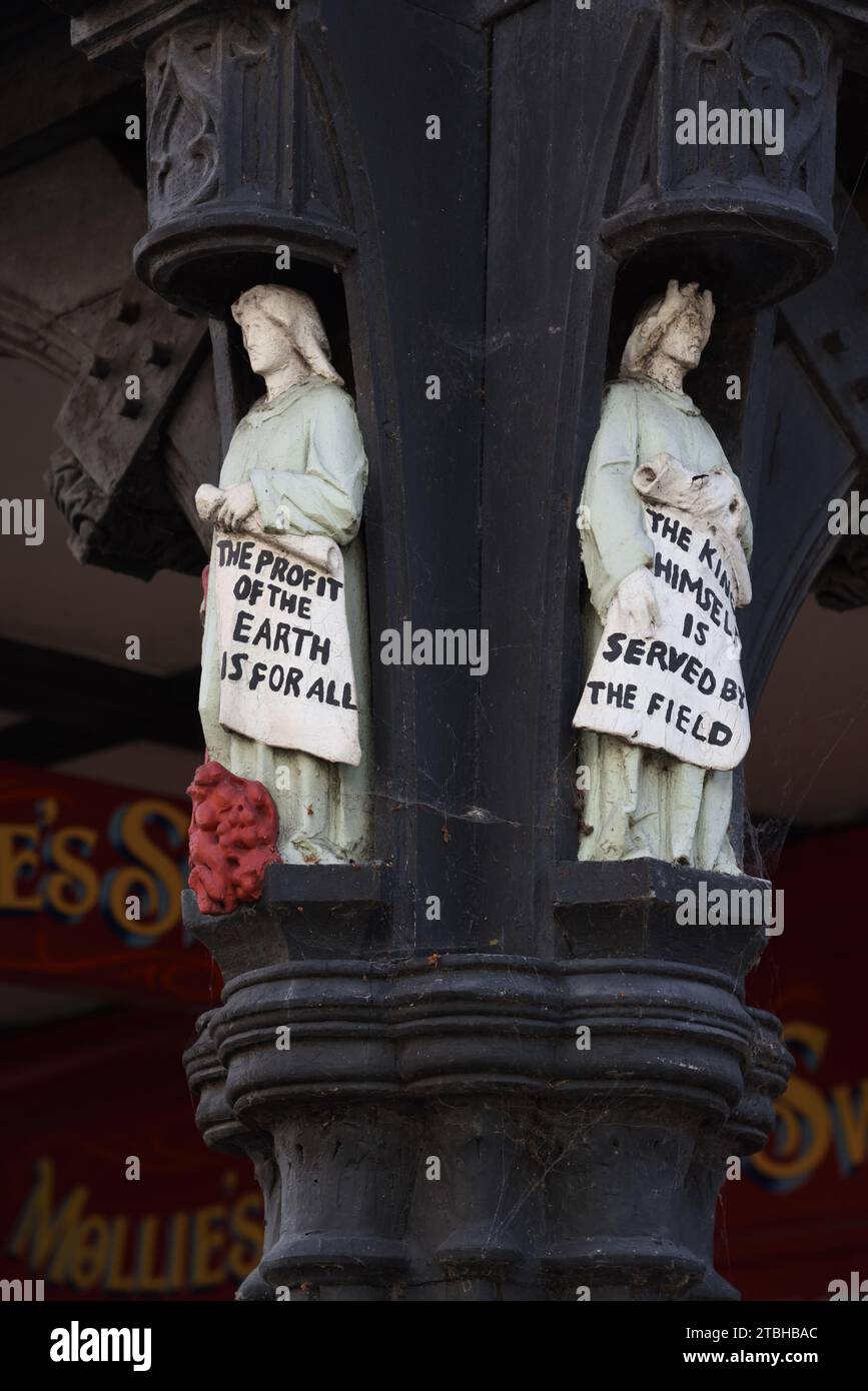Historic or Old Wood Carving or Carved Wood Figurines with Socialist Slogan 'The Profit of the Earth is for All' The Rows Chester UK Stock Photo
