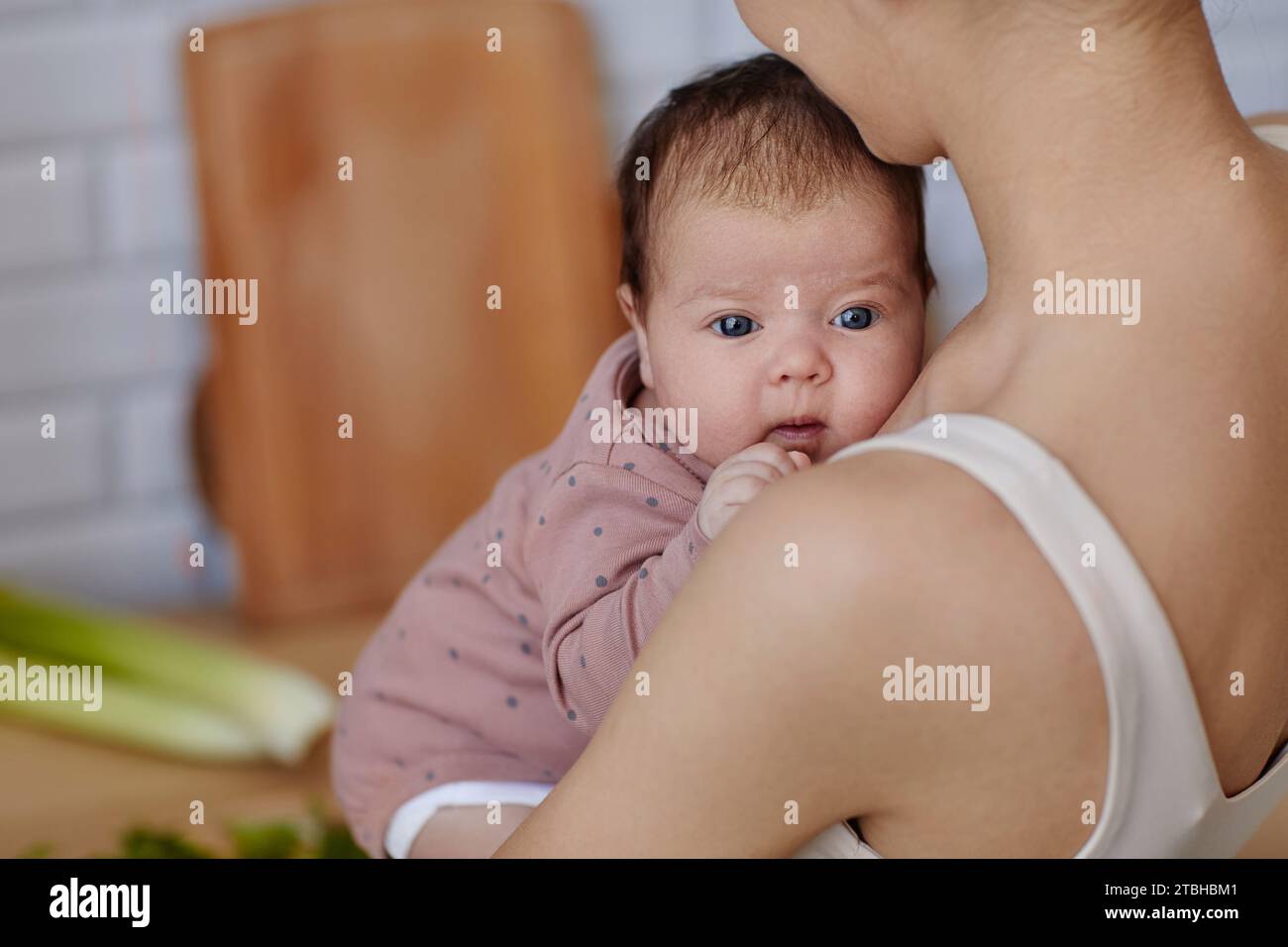 Curious Baby Looking over Mothers Shoulder Stock Photo