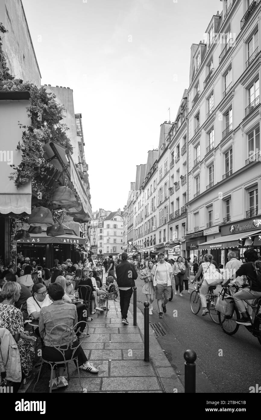 Paris, France - October 8, 2023 : Tourists and Parisians enjoying food and drinks outdoors at a the popular Rue de Buci in Saint Germain Paris France Stock Photo