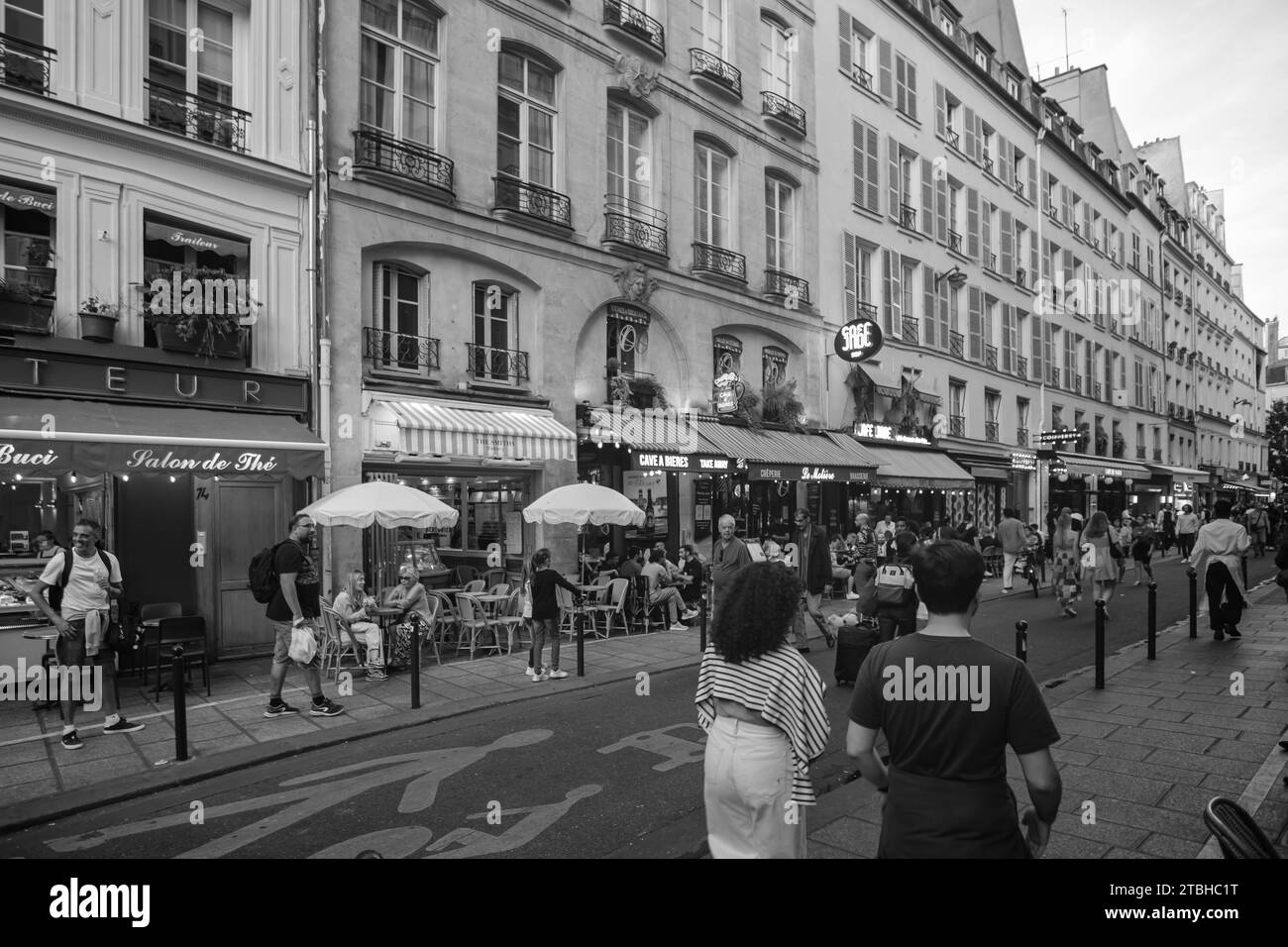 Paris, France - October 8, 2023 : Tourists and Parisians enjoying food and drinks outdoors at a the popular Rue de Buci in Saint Germain Paris France Stock Photo