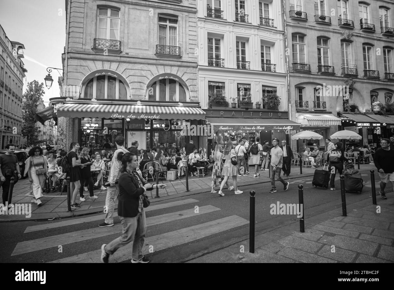 Paris, France - October 8, 2023 : Tourists and Parisians enjoying food and drinks outdoors at a the popular Rue de Buci in Saint Germain Paris France Stock Photo