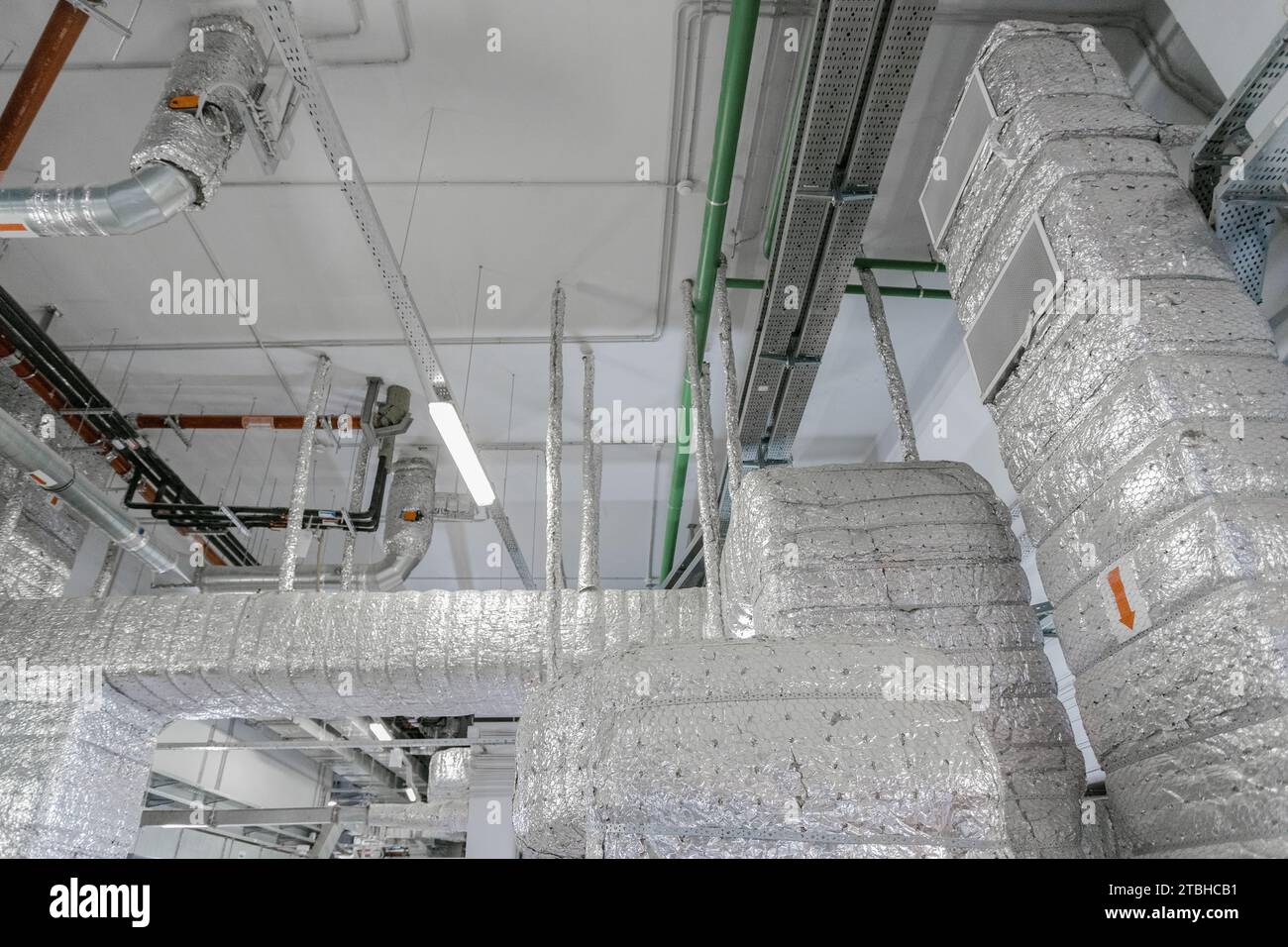 An long ventilation pipe in a technical room of a large building. Air