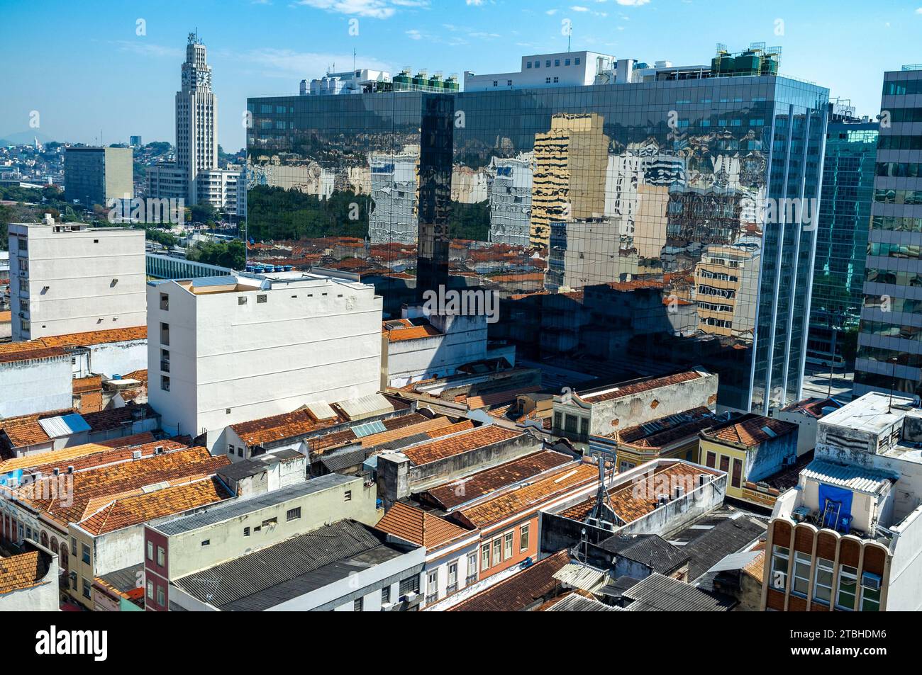 Urban contrast - preserved sobrados, two or more story ancient houses from the colonial and imperial periods in Brazil at the heart of the popular commerce region known as Saara in downtown Rio de Janeiro, next to corporate modern buildings. Central do Brasil train station building in background left. Stock Photo