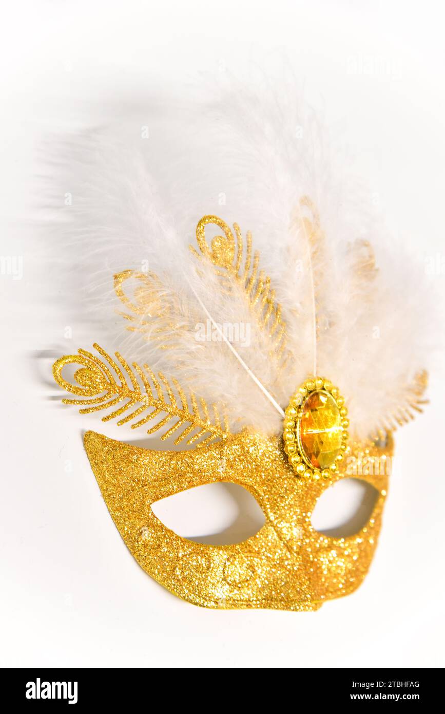 Golden masquerade mask with feathers on a white background Stock Photo