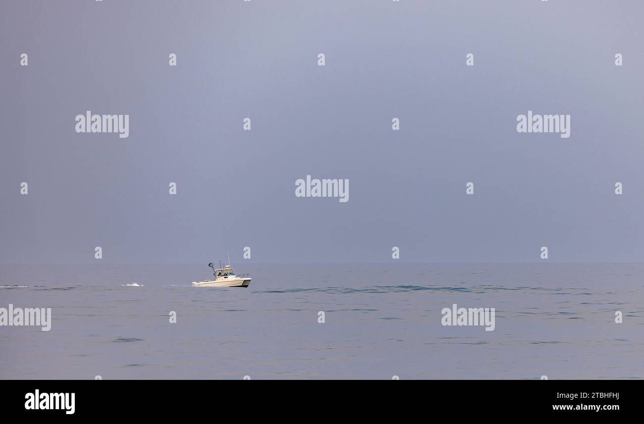 small white power boat off flying point beach Stock Photo