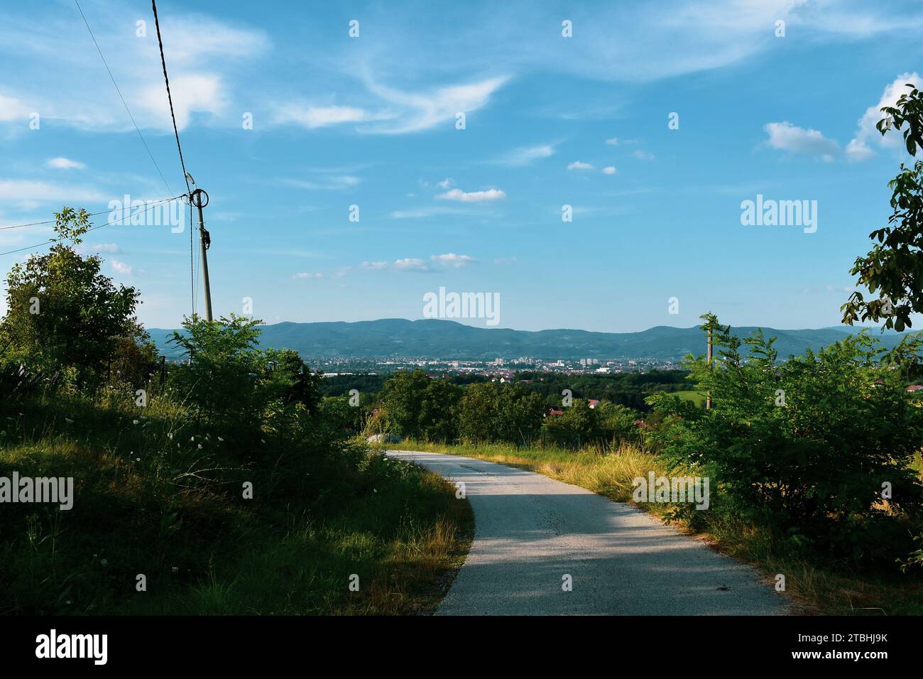 A country road with a view of the country houses and the city in the ...