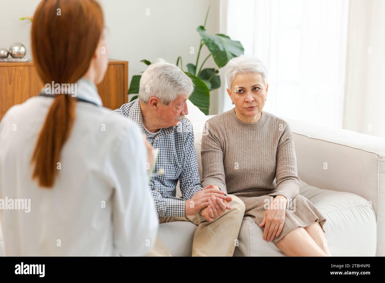 Female doctor examining older senior couple in doctor office or at home ...