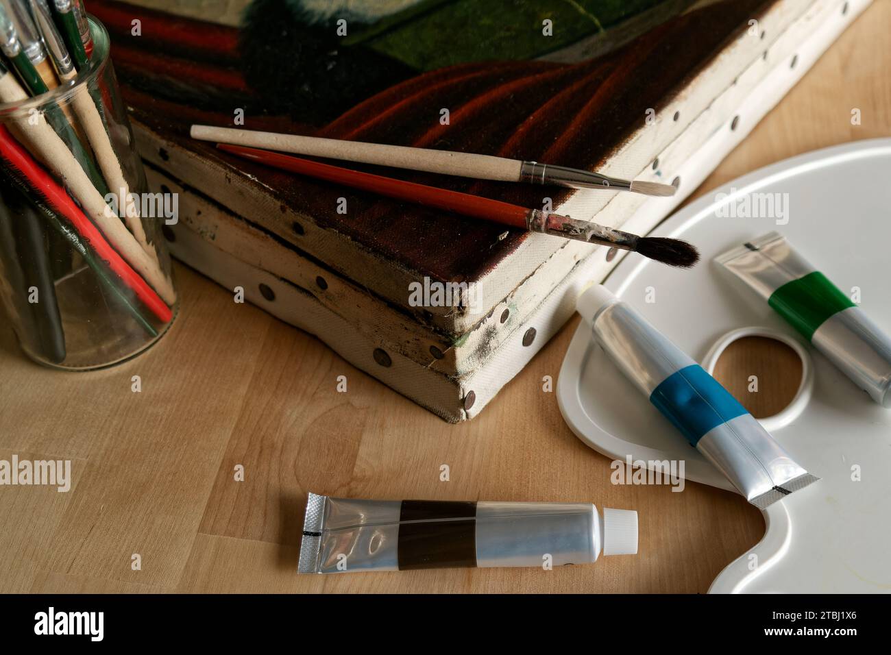 Still life with oil paintings on canvas with brushes and tubes of paint