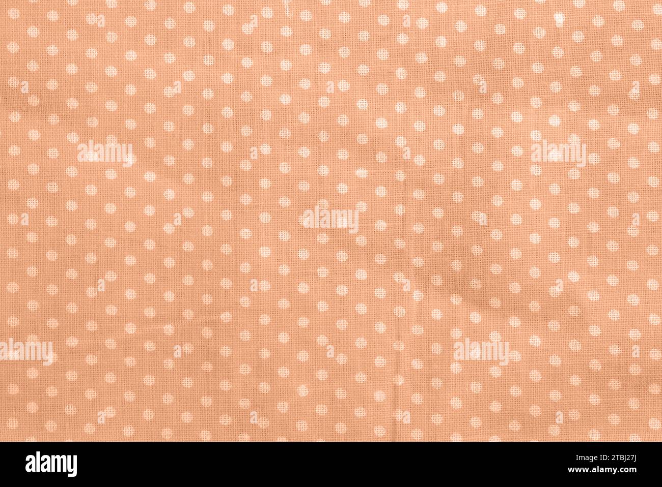 Peach fuzz polka dot cotton texture. Fabric textile background Stock Photo
