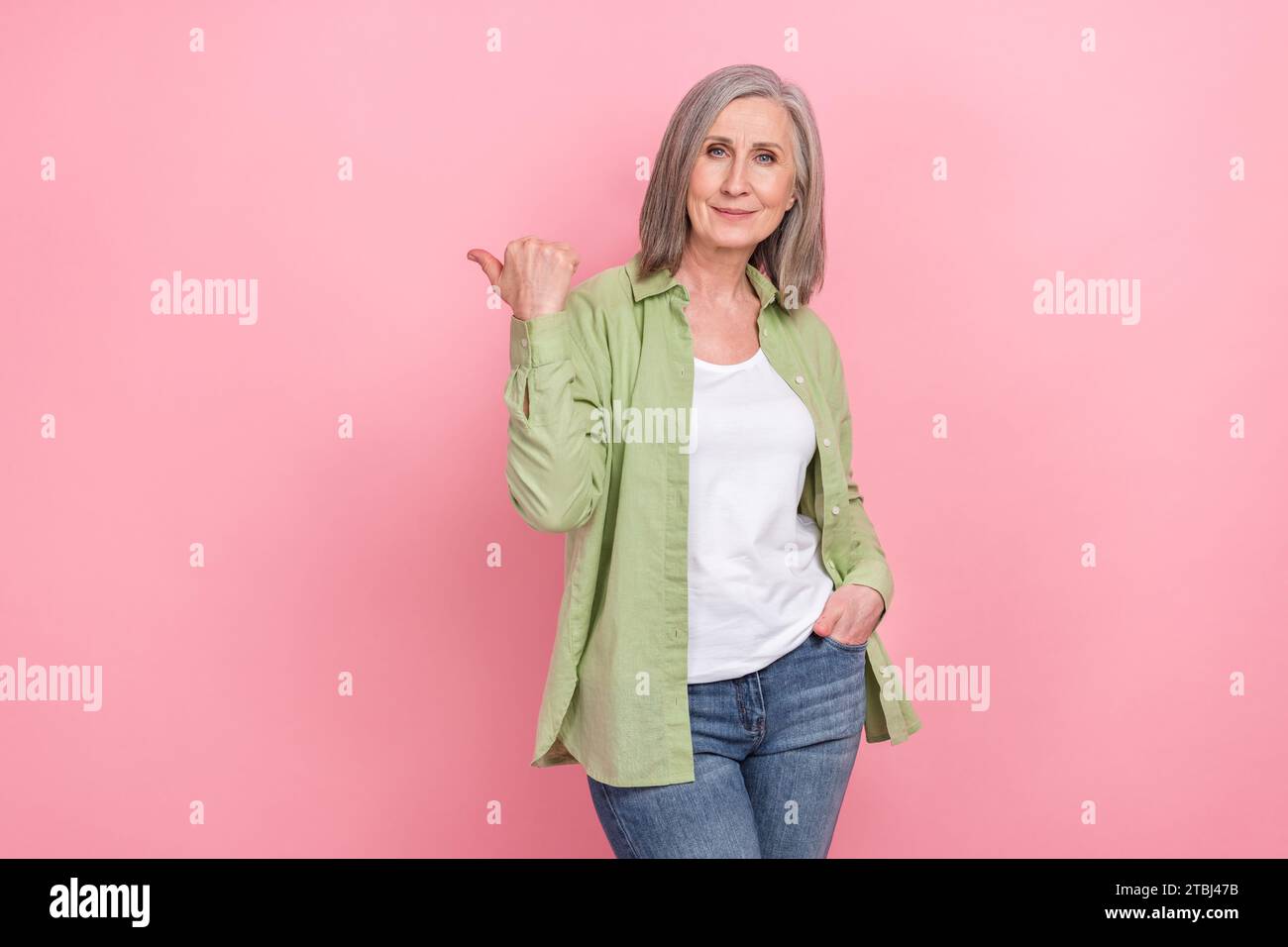 Photo of old white haired pointing finger information empty space presentation just content no ads isolated on pink color background Stock Photo