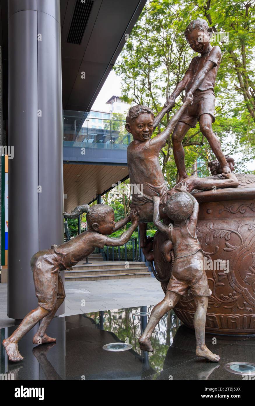 BUDAK-BUDAK is a life-size bronze statue of children playing by Chong Fah Cheong outside The Heeren, Orchard Road, Singapore Stock Photo