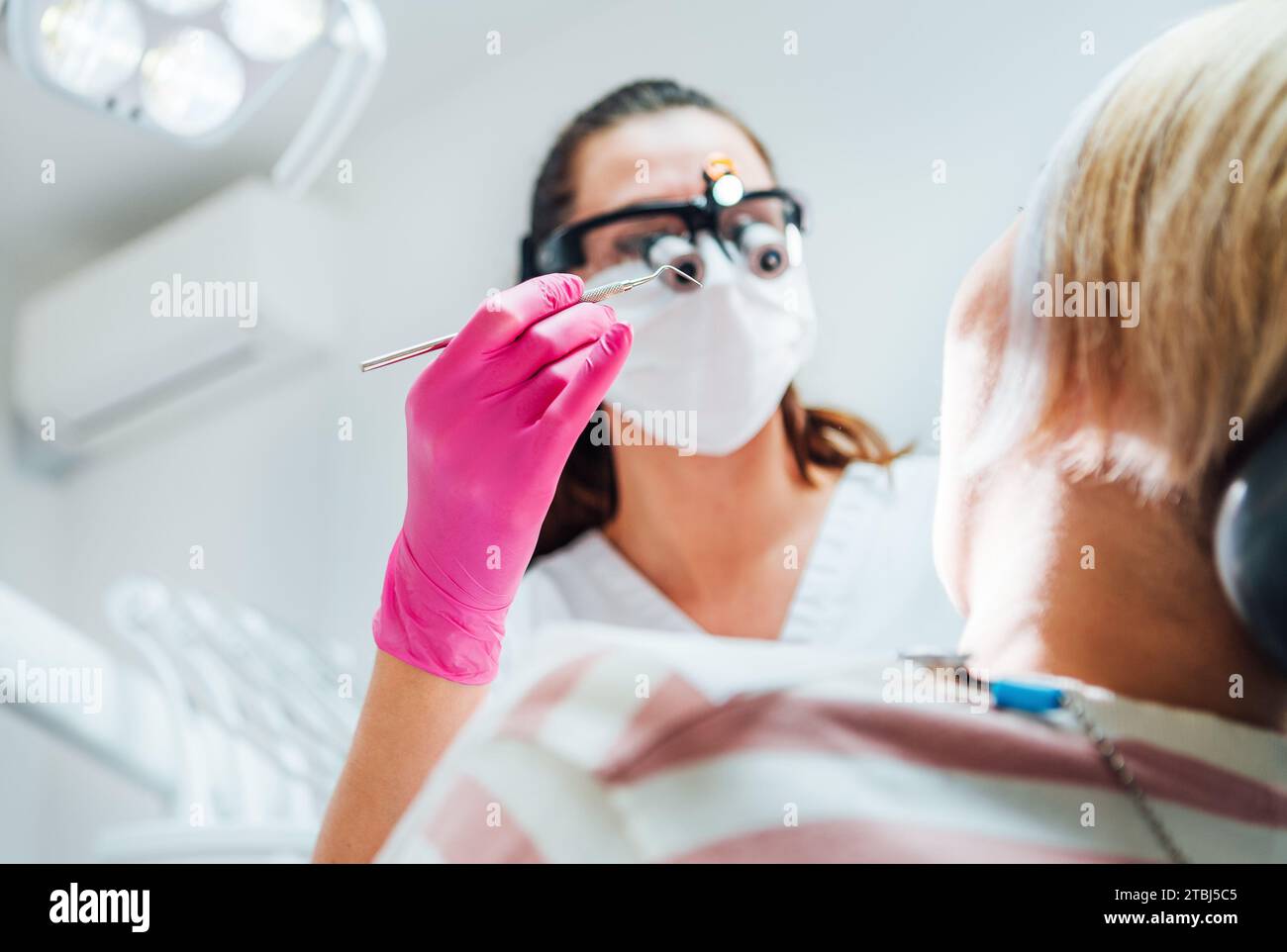 Dentist doctor in magnifying glasses with Dental explorer tool. Young ...