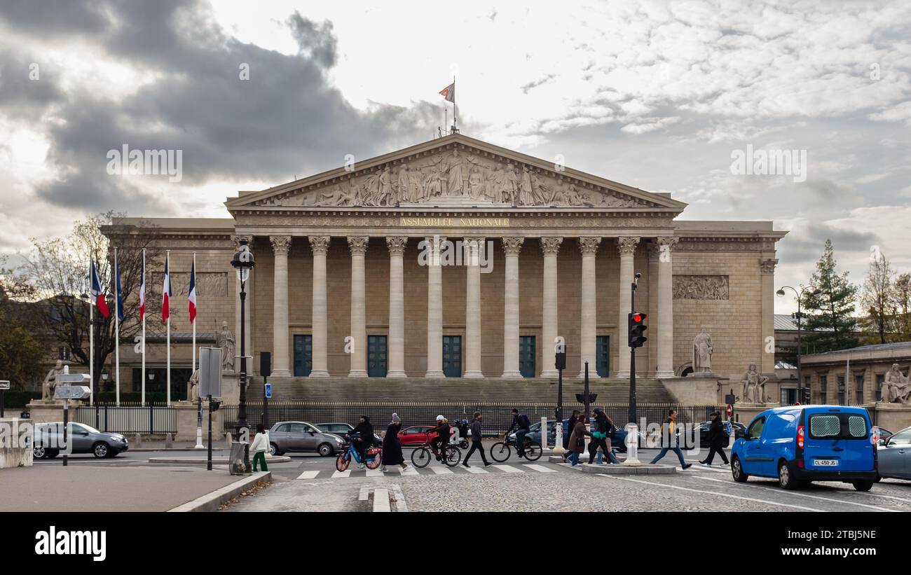 Paris, France, 2023. People walking across the Pont de la Concorde in front of the Palais Bourbon which houses the National Assembly Stock Photo