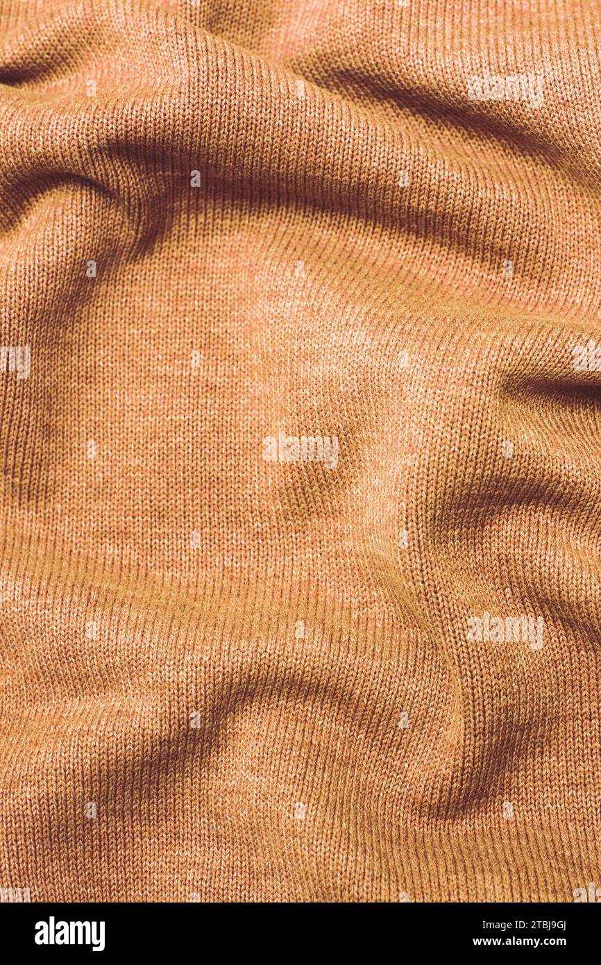 burgundy Peach Fuzz wrinkled plush fabric background texture, soft material pattern. Color of the year 2024 Stock Photo