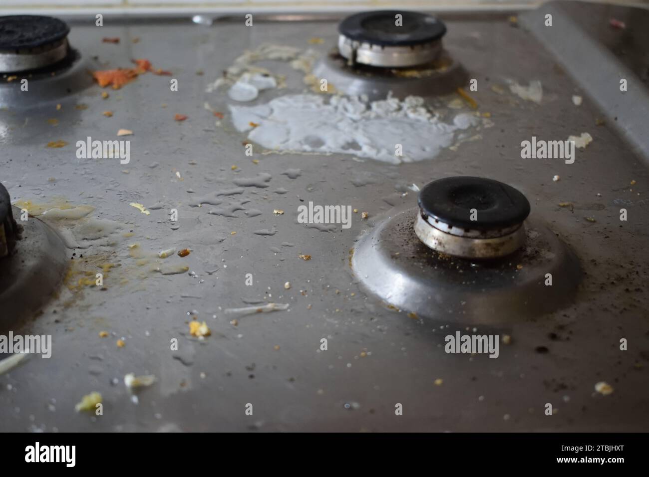 non edited photo of Dirty stove in the kitchen with food leftovers. Unclean gas kitchen cooktop with greasy spots, old fat stains, fry spots and oil Stock Photo