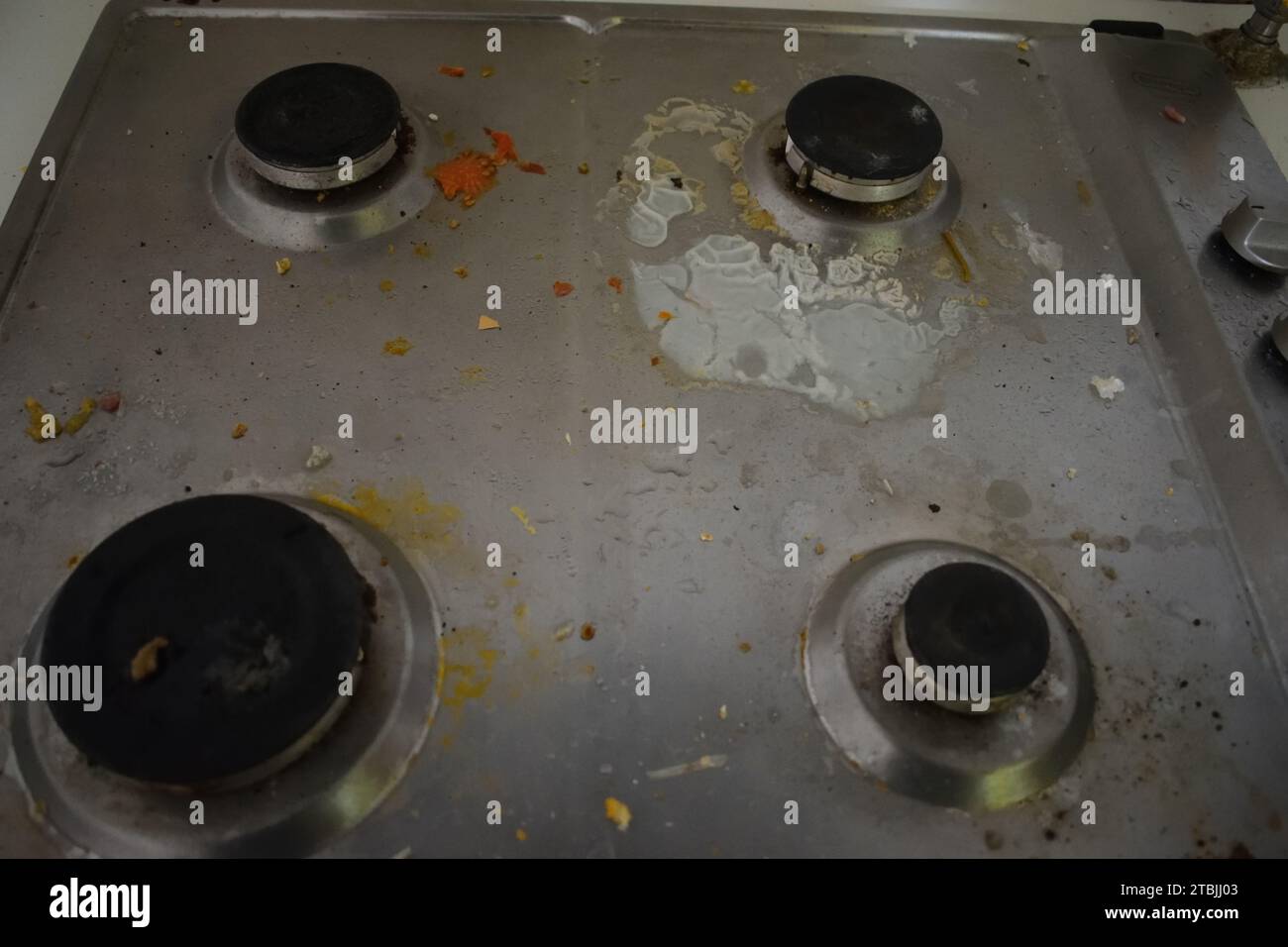 non edited photo of Dirty stove in the kitchen with food leftovers. Unclean gas kitchen cooktop with greasy spots, old fat stains, fry spots and oil Stock Photo