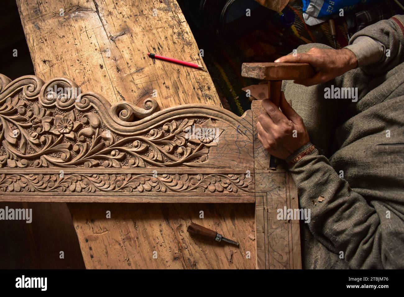 A Kashmiri artisan carves a handicraft item at a wood carving factory