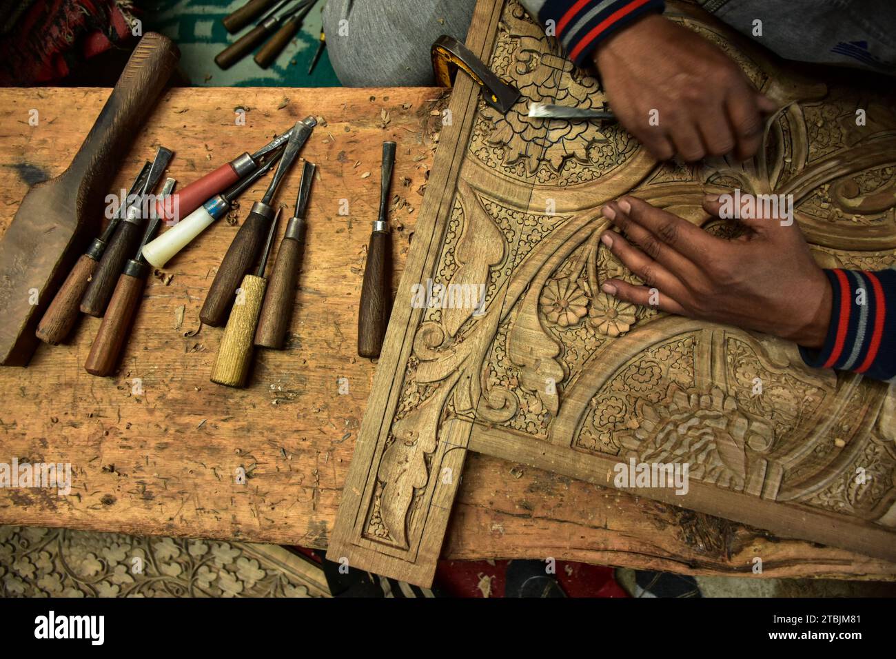A Kashmiri artisan carves a handicraft item at a wood carving factory