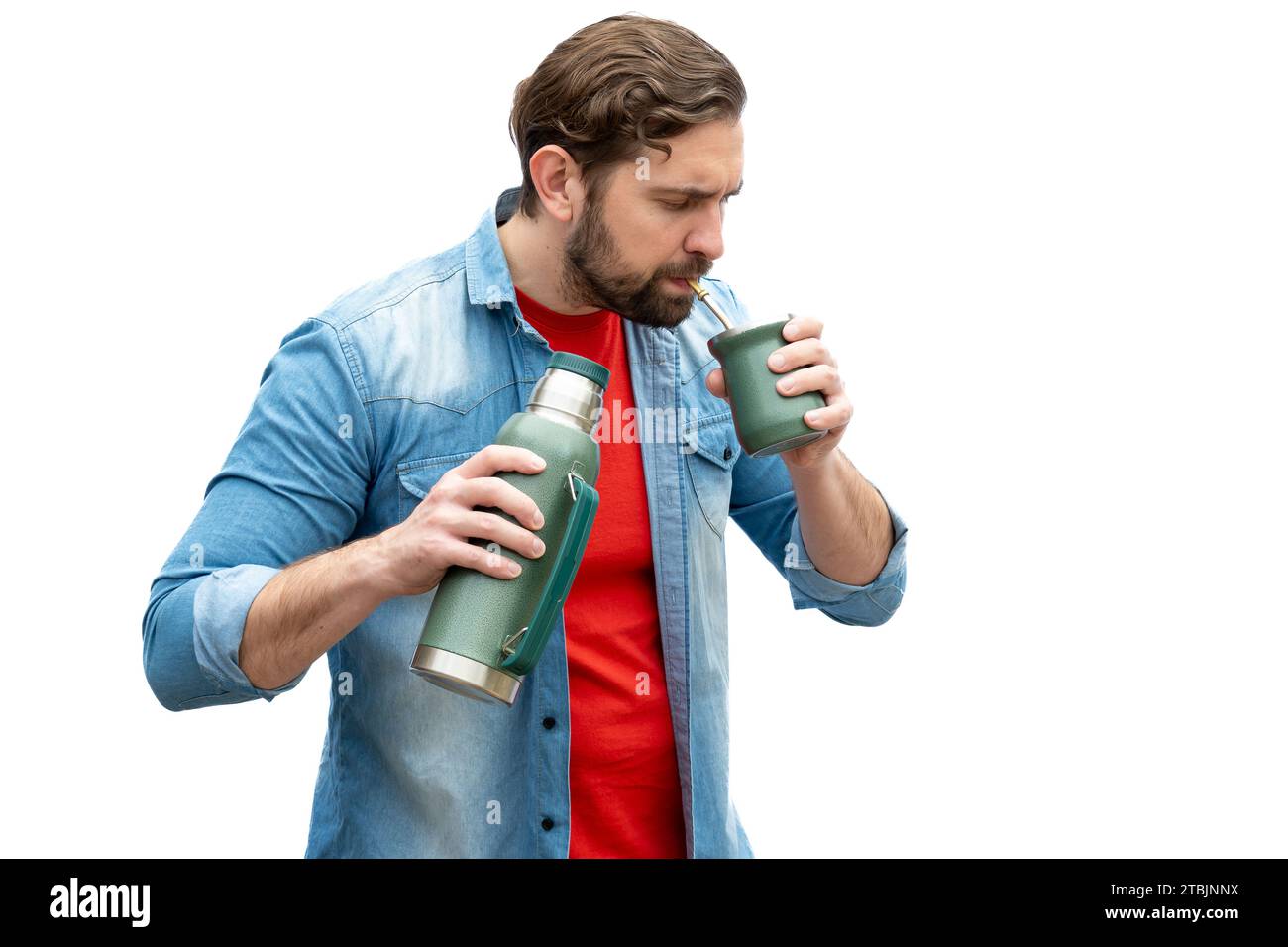 Young adult drinking mate, with a thermos in his hand. Stock Photo