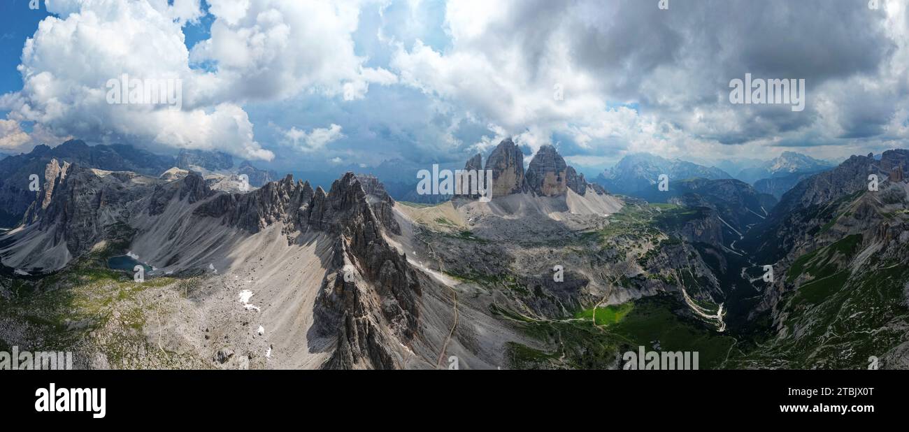 Aerial panoramic view of Tre Cime di Lavaredo mountain during a sunny day with clouds and fog in the Dolomites, Italy. Stock Photo