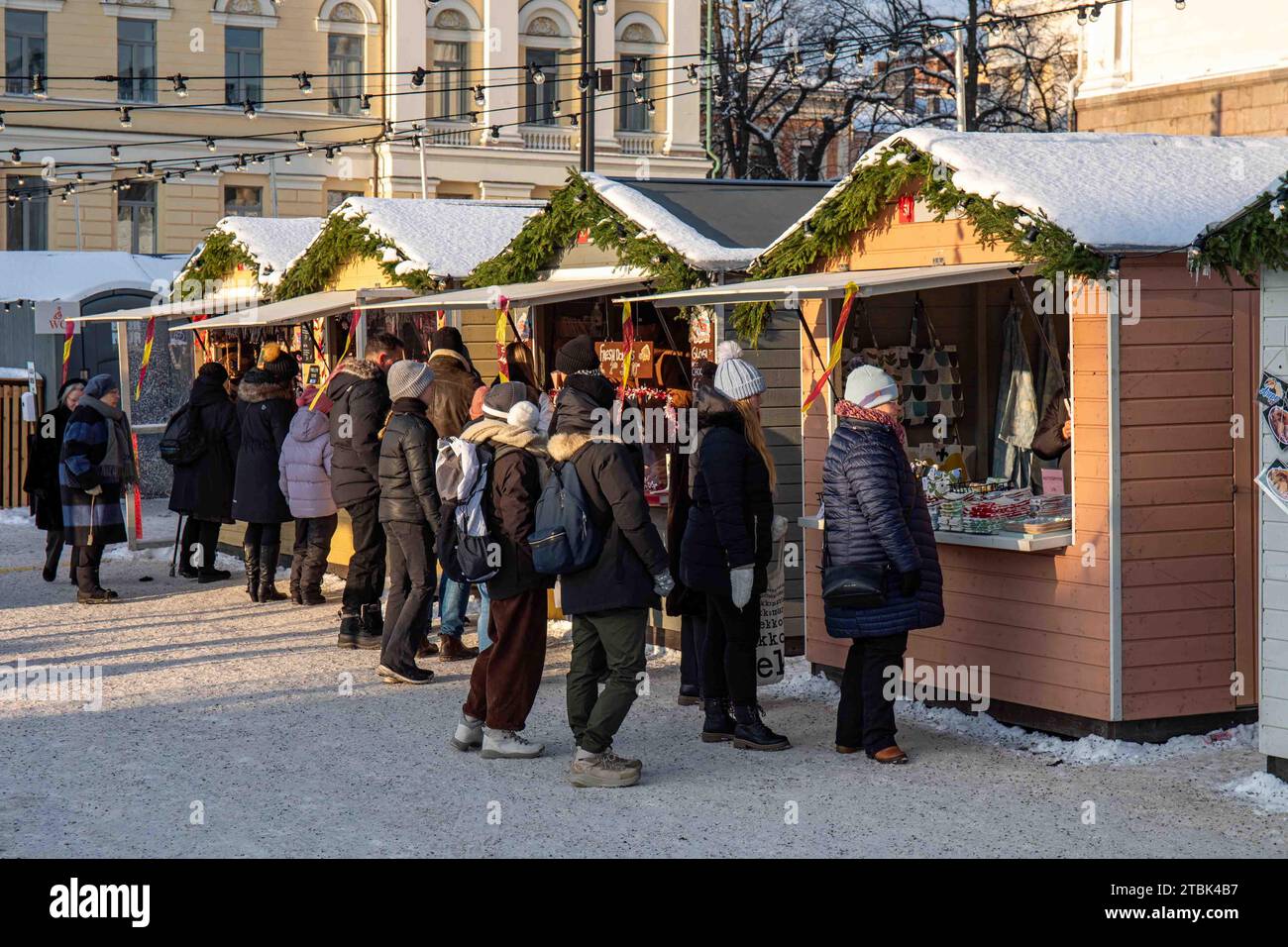 People and market kiosks at Tuomaan markkinat or Helsinki Christmas Market on Senate Square in Helsinki, Finland Stock Photo