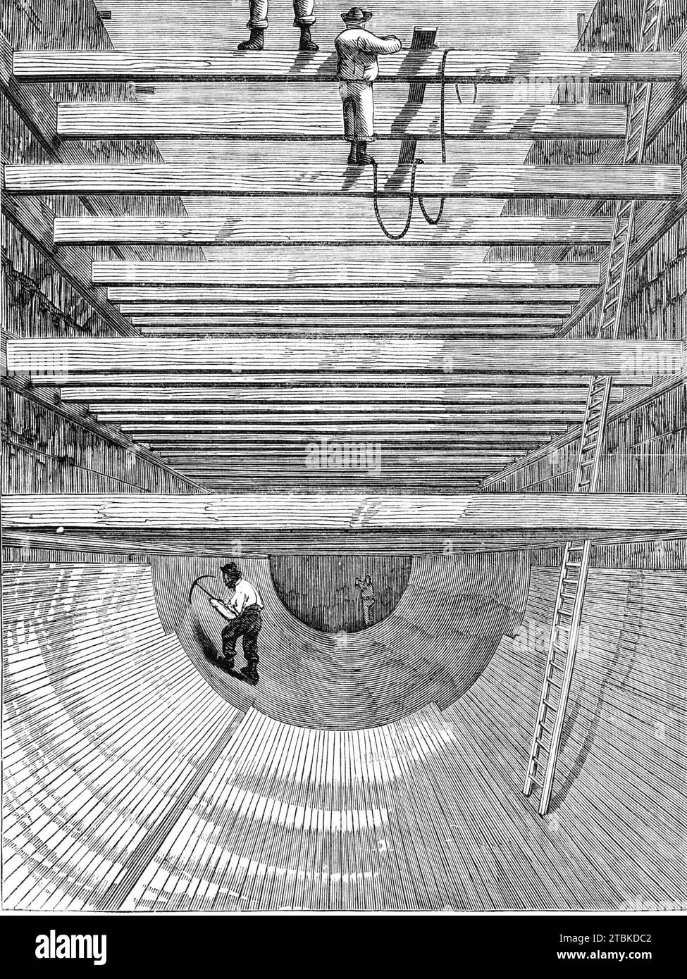 London Main Drainage: constructing the invert for the southern high-level sewer, 1861. 'The northern outfall sewer is about five miles long....The remarkable manner in which the embankment or bed is formed upon which the tunnels are to be built will be best understood by reference to our Illustration. The whole of the upper soil is first excavated, then a solid embankment of concrete is formed. In some places this embankment is as much as twenty feet in depth and one hundred feet in width. It is formed by carrying out a staging upon which several lines of rails are laid. The concrete is made o Stock Photo