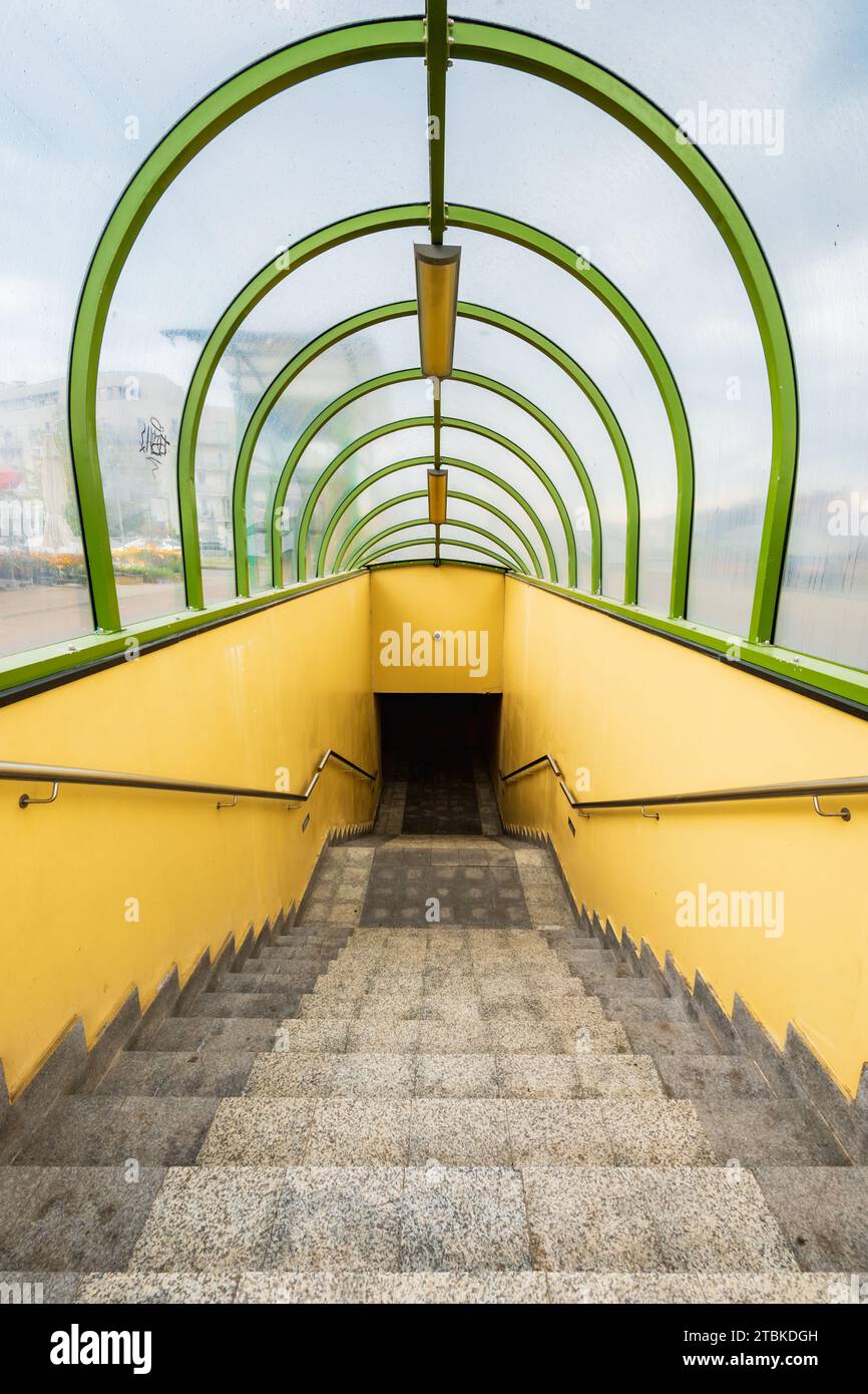 Gdansk, Poland - July 23 2023: Small tunnel with yellow walls and green arcs and with downstairs to underground passage under streets Stock Photo
