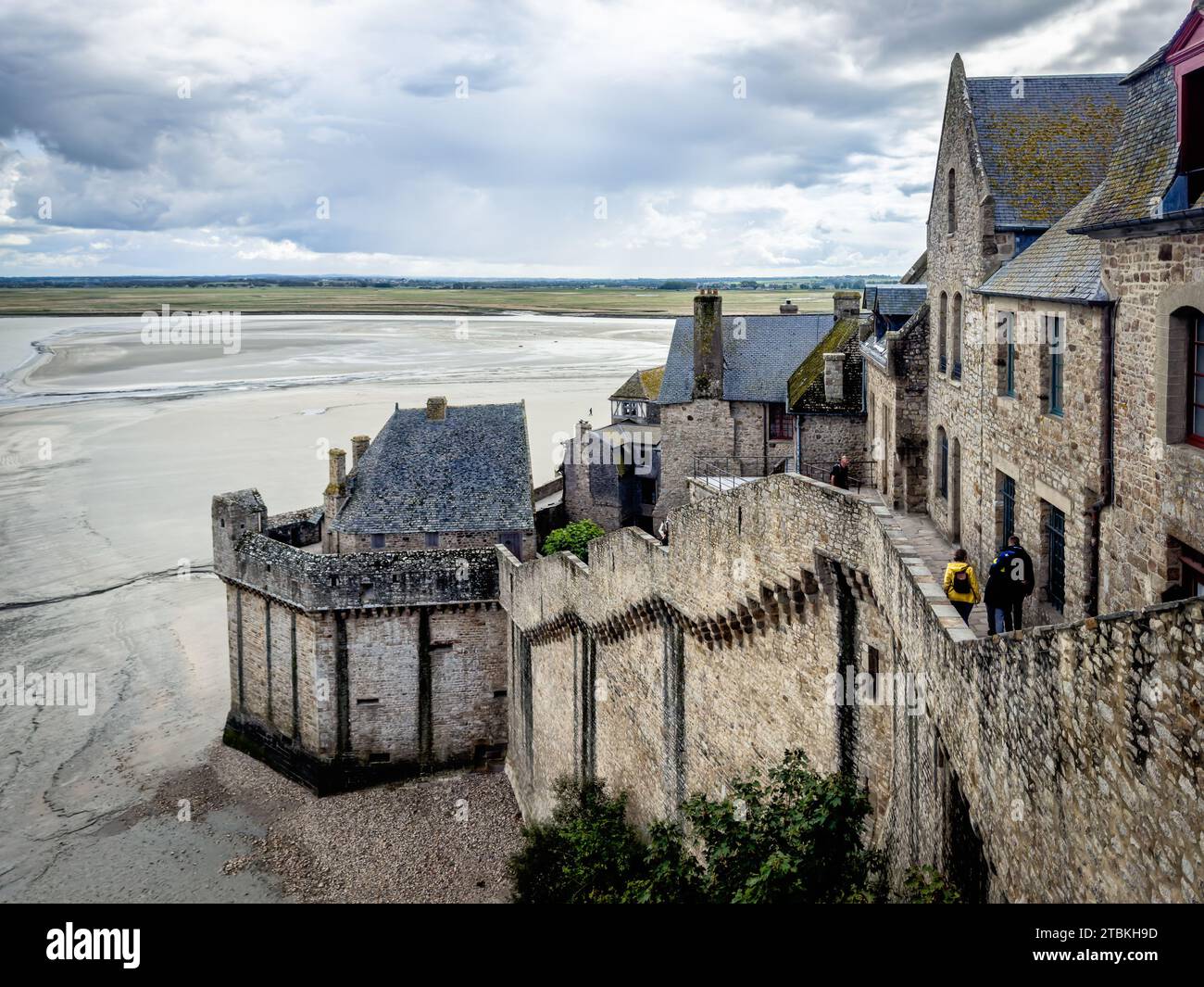 Normandy, France, Sept 22nd 2023, view of some people walking on one of the curtain walls of the Mont Saint-Michel Stock Photo