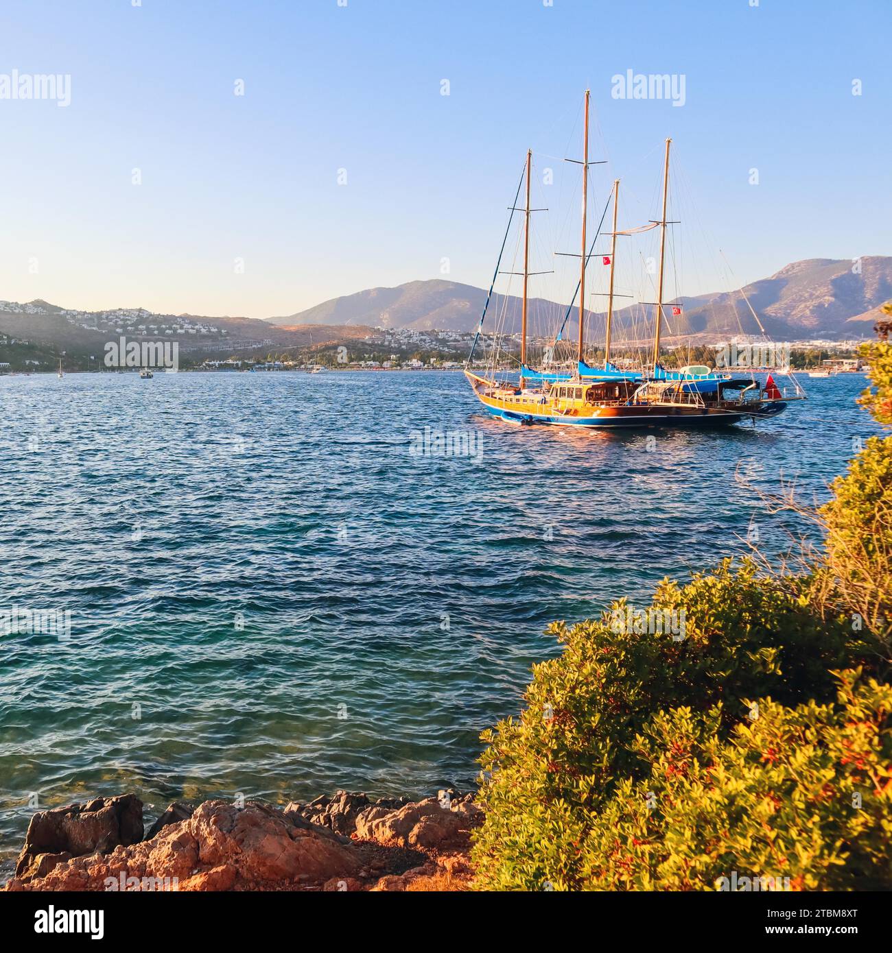 Beautiful Mediterranean coast with islands, mountains and yacht at sunset Stock Photo