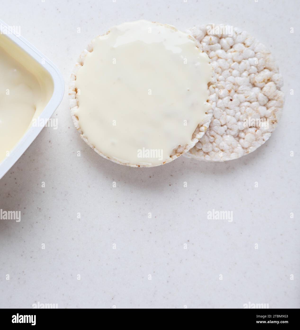 Healthy organic rice cakes with cream cheese on white marble Stock Photo