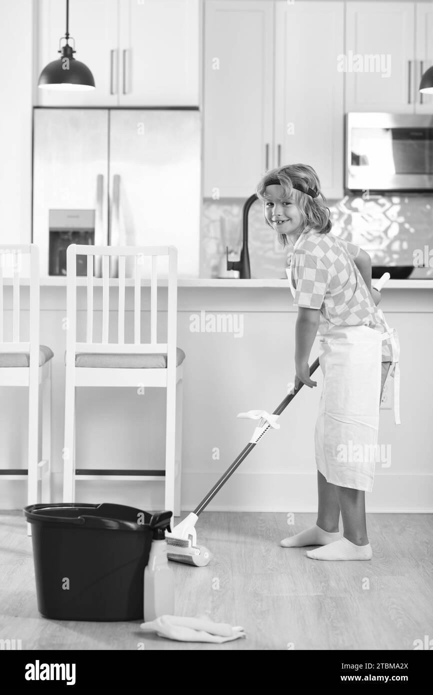 Child do chores cleaning floor. Portrait of child helping with housework, cleaning the house. Housekeeping, home chores. Stock Photo