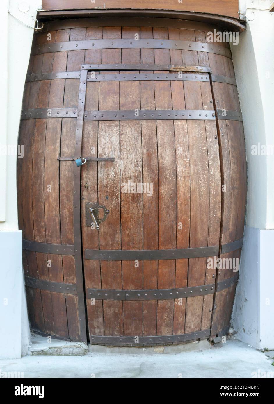 Wooden barrel door. Door in the shape of the wine barrel Stock Photo