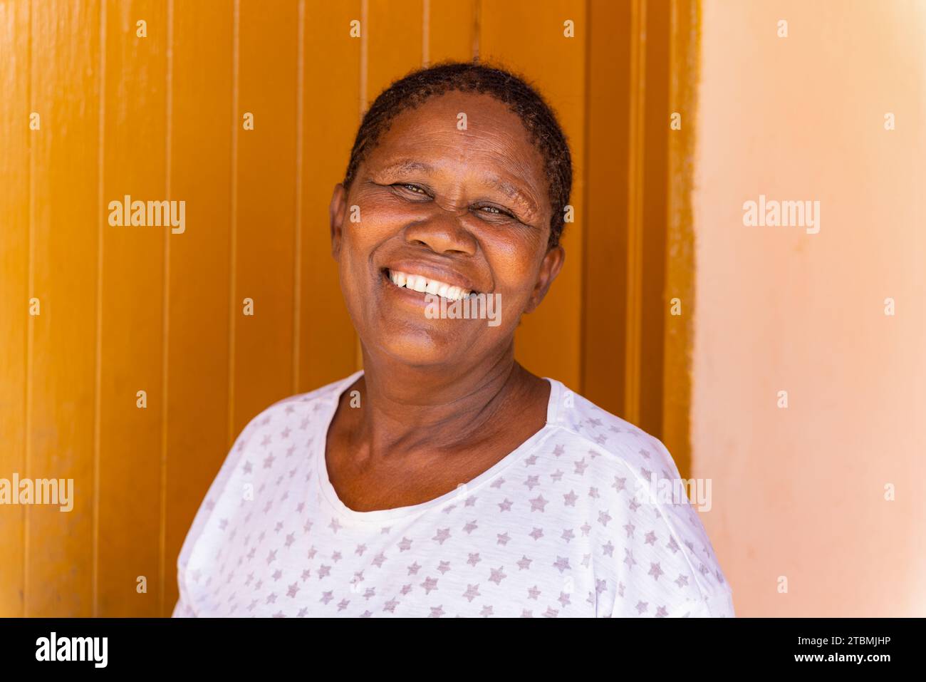 portrait of village african granny, standing in front of the house , large copy space Stock Photo