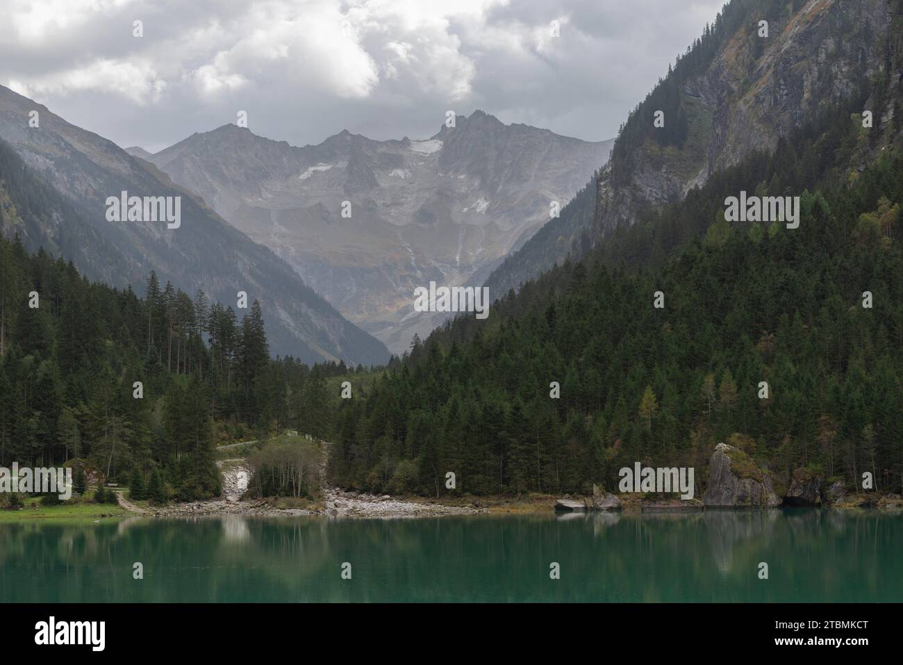 Stilluptal, Stiillup reservoir (1116m), Stillupgrund, Mayrhofen, reservoir lake, alpine mountain landscape, coniferous forest, haze, Zillertal Alps Stock Photo