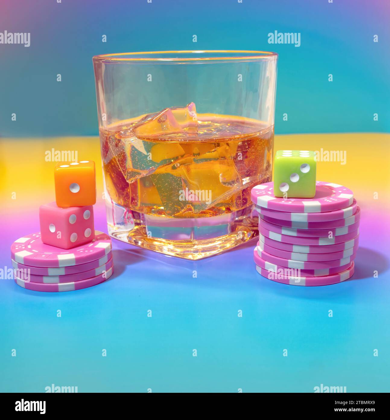 A Glass of Scotch Whiskey, Pink Poker Chips and Dice on a Light Pastel Background in a Casino Table Scene Stock Photo