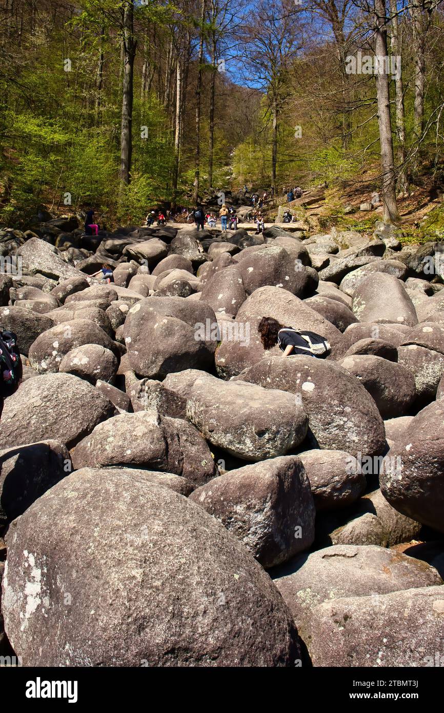 Lautertal, Germany - April 24, 2021: People climbing on large rocks at Felsenmeer on a spring day in Germany. Stock Photo