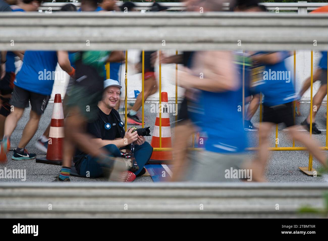 Singapore - Dec 2, 2023: Photographer urging the runners on during the Standard Chartered Singapore Marathon 2023. Stock Photo