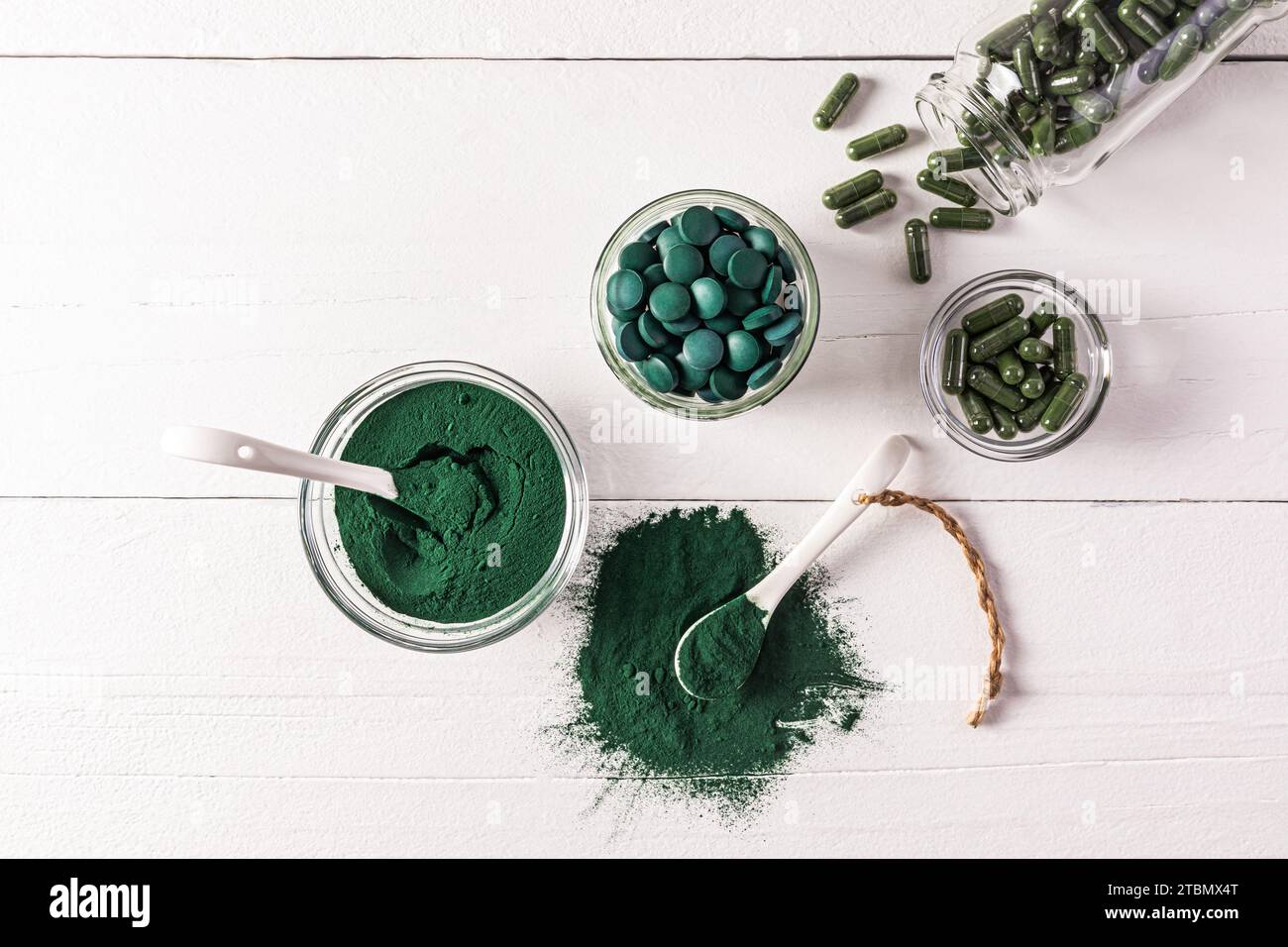 Round bluegreen natural spirulina algae tablets and powder in bowl on