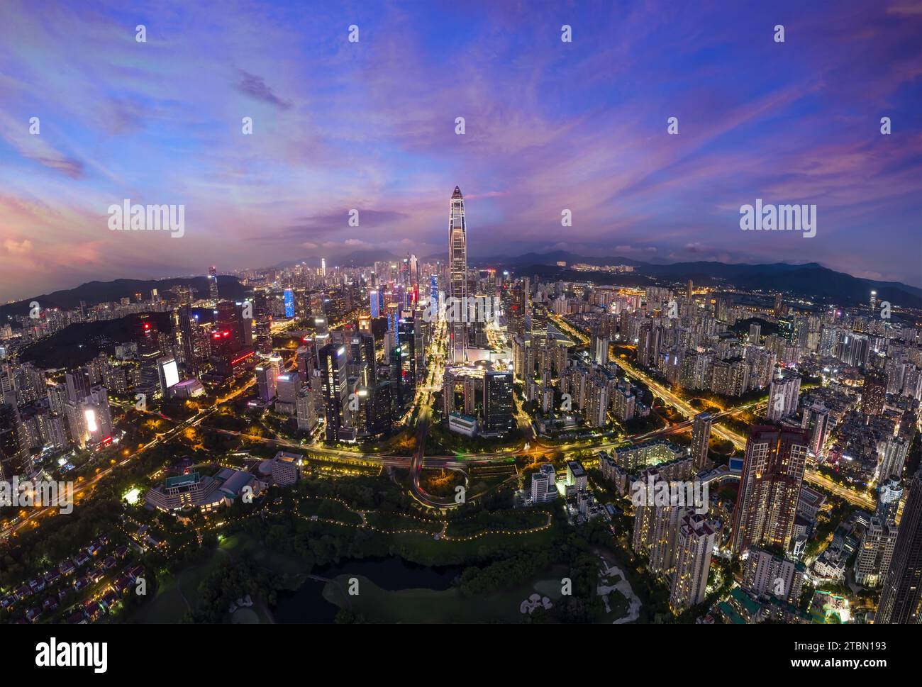 Drone fly over Shenzhen city central business district, aerial panorama China at night. Stock Photo