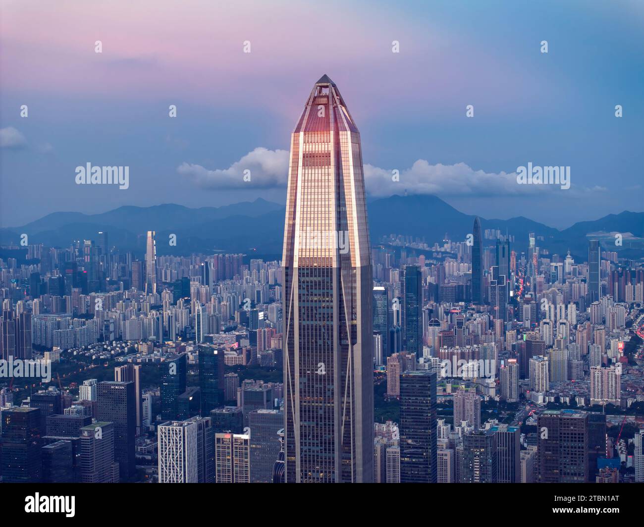 Drone fly over Shenzhen city central business district, aerial panorama China at night. Stock Photo