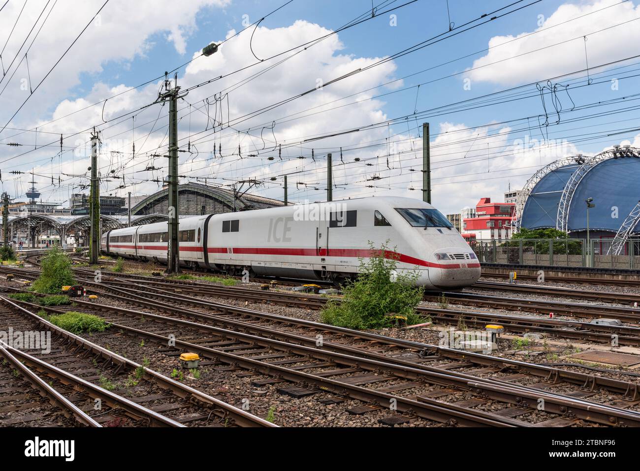 Cologne (Köln), Germany - June 11, 2022: Back view of the Cologne Central Station with steel construction, railway track and the high-speed ICE train Stock Photo