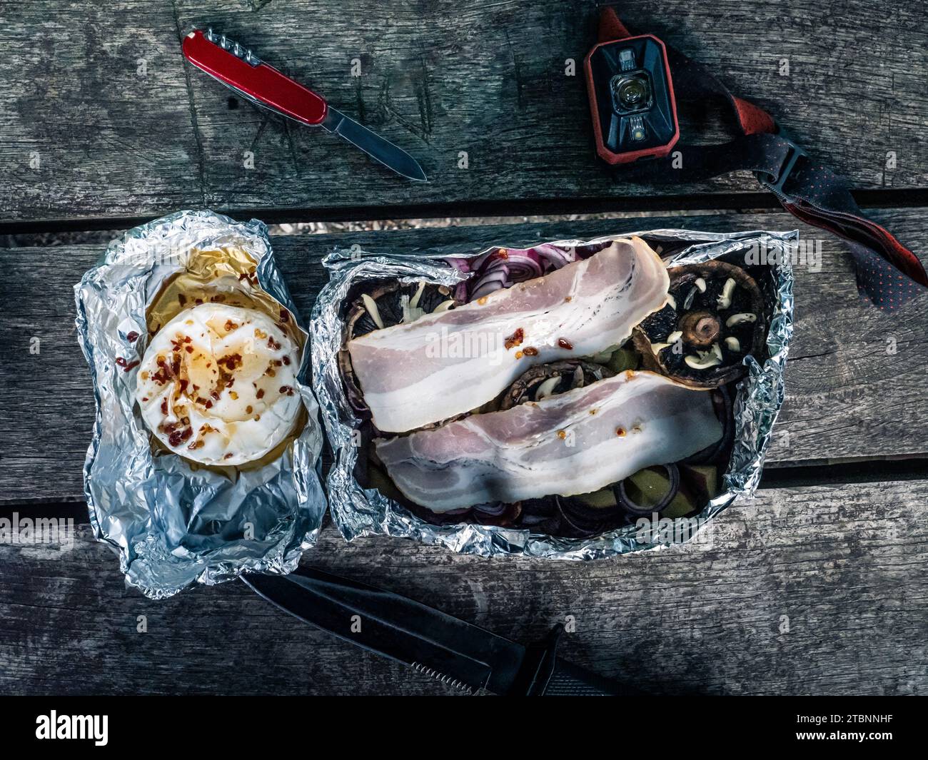 Tin foil packages of grilled food mushroom onion garlic bacon camembert