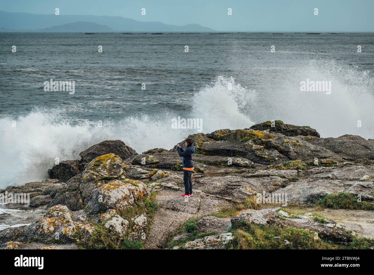 Tourist taking a picture of the breaking waves Stock Photo