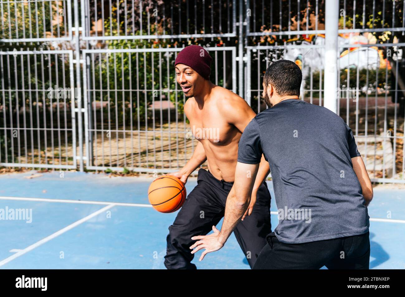 man in defense playing basketball with his friend Stock Photo
