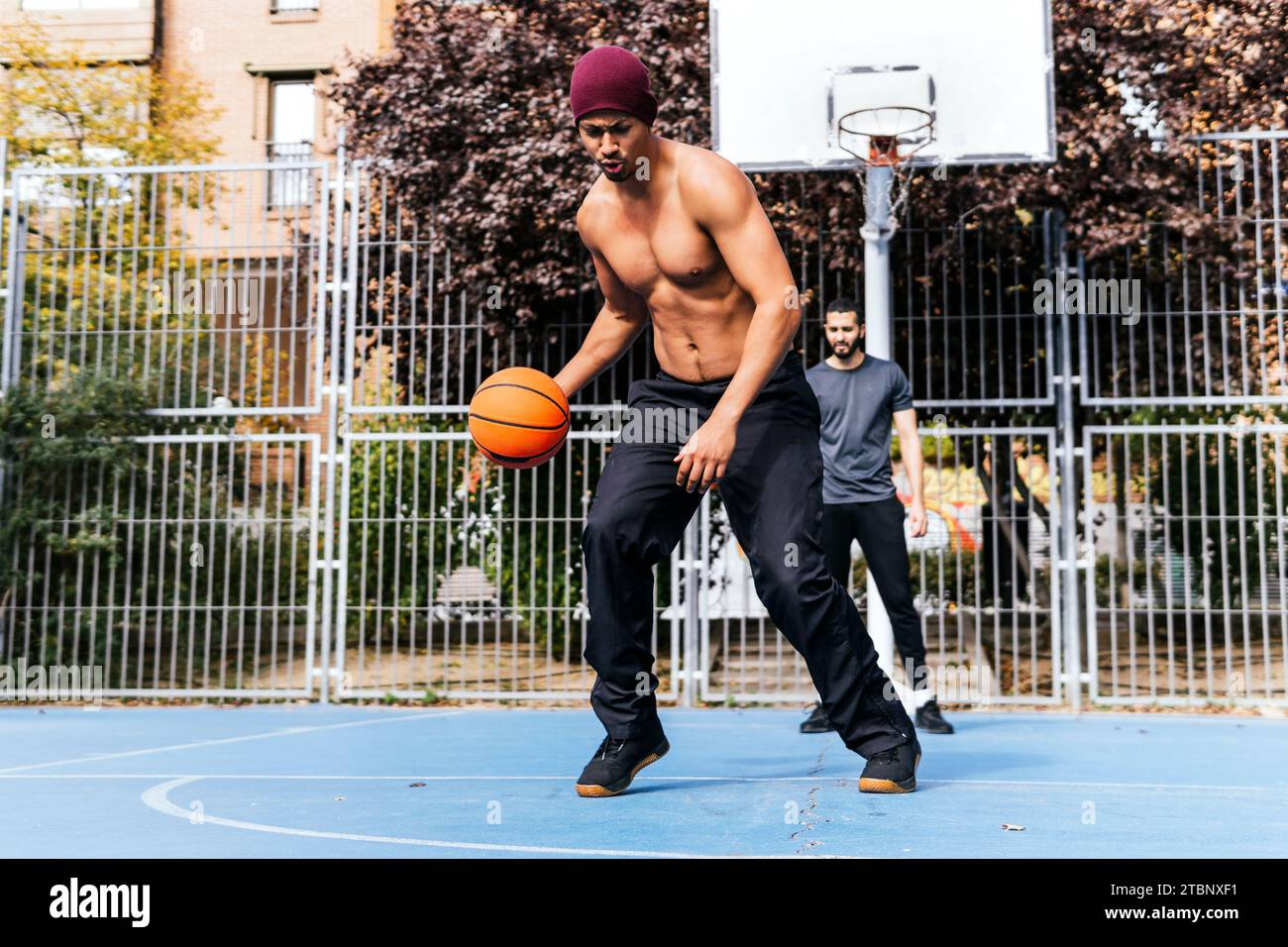 man in defense playing basketball with his friend Stock Photo