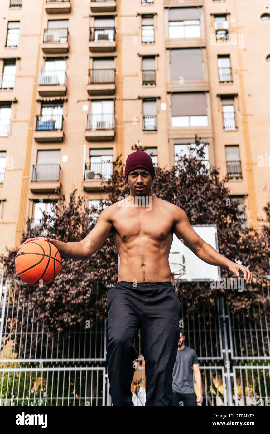 multiracial man playing basketball with his friend Stock Photo